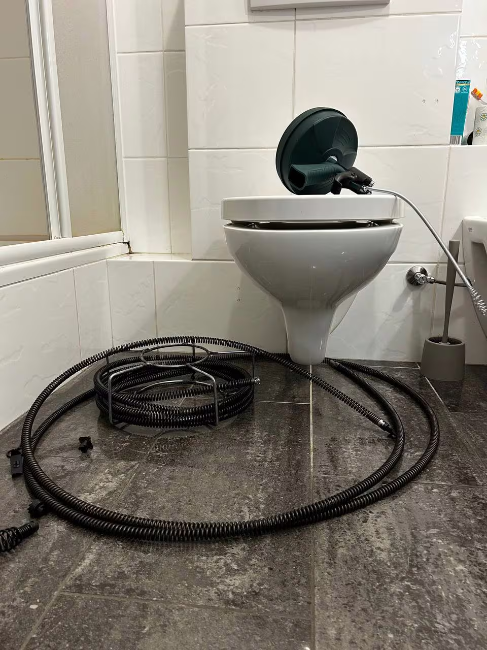 Udrażnianie kanalizacji spiralą mechaniczną napędzaną wiertarką – toaleta w mieszkaniu, Warszawa